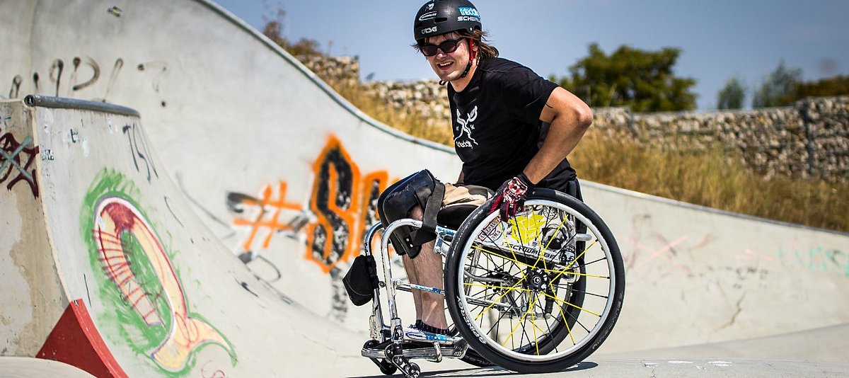 Wheelchairskater David Lebuser in seinem Rollstuhl beim Skaten in der Halfpipe.