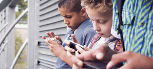 Kleine Jungs gucken auf ihre Smartphones