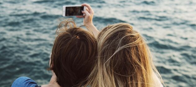 Zwei Jugendliche machen ein Selfie mit einem Smartphone