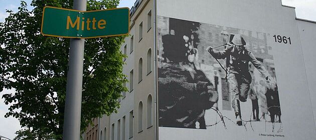 Ein drei Etagen hohes Mural in Berlin-Mitte zeigt Conrad Schumann, den 19-jährigen Polizisten der Volkspolizei der DDR genau in dem Moment, als er über Stacheldraht springend aus der DDR floh.