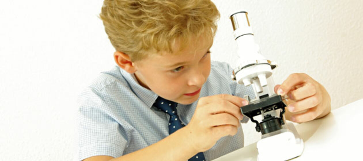 Ein kleiner Forscher mit Mikroskop