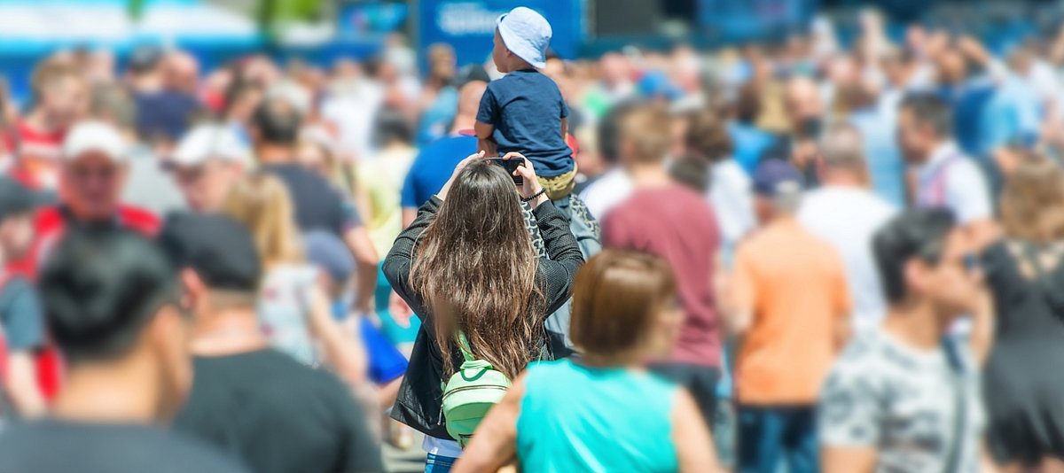 Menschenmenge mit Vater, der sein Kind auf den Schultern trägt
