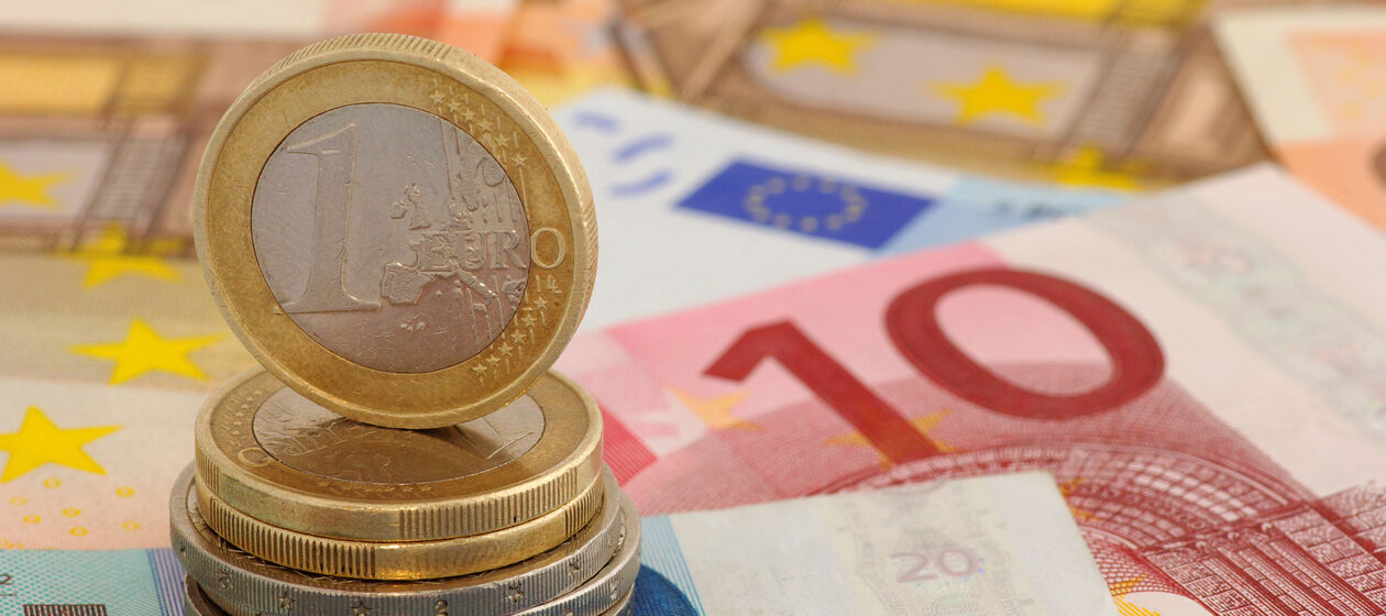 Stehende Euromünze auf Scheinen