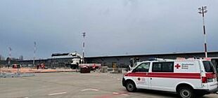 Aufbau eines Großzeltes am ehemaligen Flughafen Berlin Tegel. Rechts im Vordergrund steht ein Fahrzeug des Deutschen Roten Kreuz.