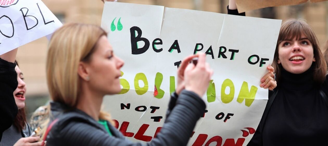 Junge Menschen nehemn an einer Demonstration gegen Klimaschutz teil und halten selbst gemalte Schilder hoch