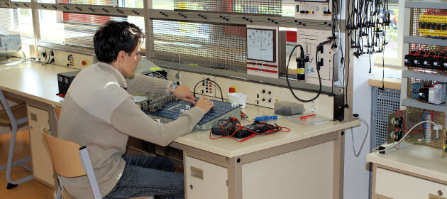 Ein Auszubildener arbeitet mit Kabeln und Elektrotechnik