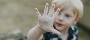 Ein Kind streckt die Hand in die Kamera