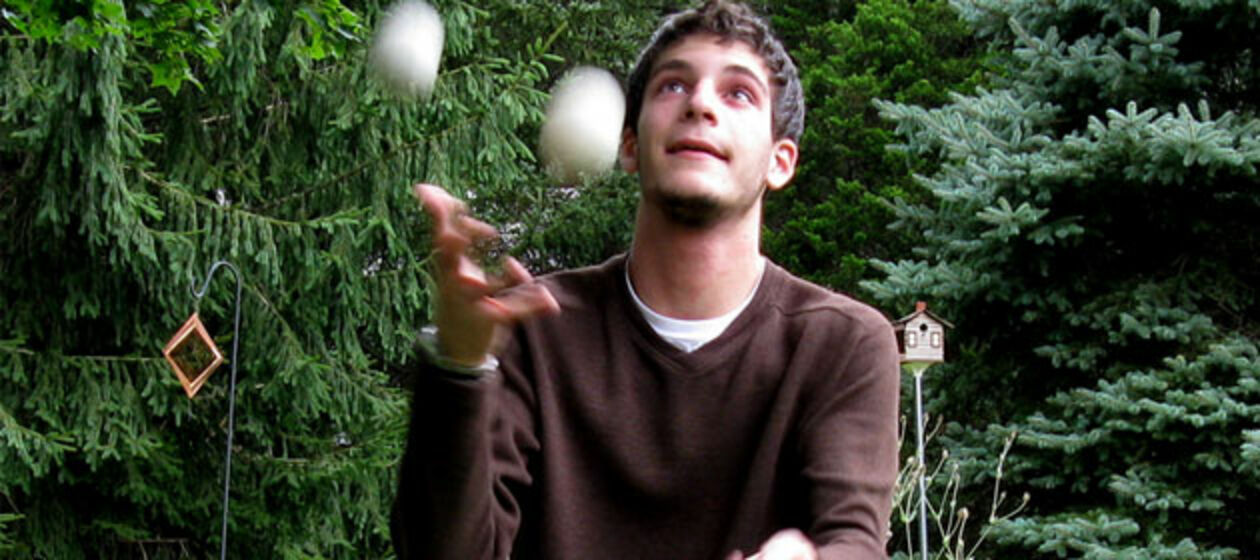 Junger Mann jongliert