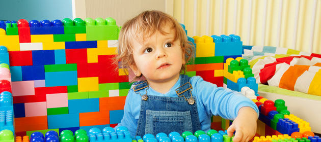 Ein kleiner Junge umringt von Lego