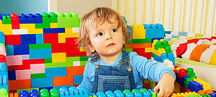 Ein kleiner Junge umringt von Lego