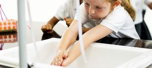 Ein Kind wäscht die Hände im Waschbecken
