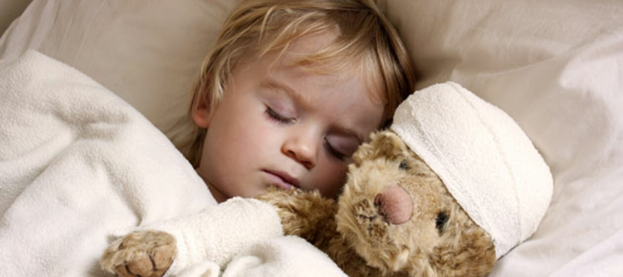 Ein schlafender Junge mit Teddybär im Arm