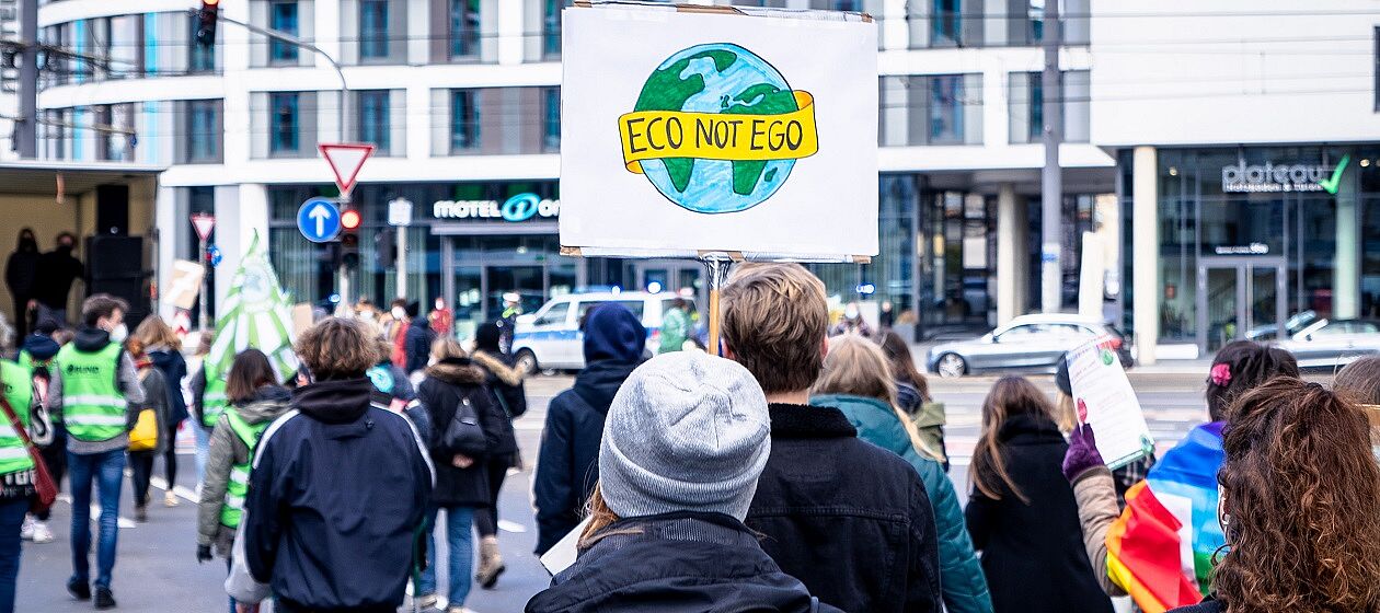 Ein Protestzug mit jungen Menschen, auf einem Schild steht Eco not Ego