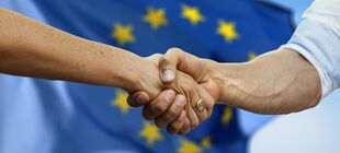 Ein Handschlag vor der EU-Flagge