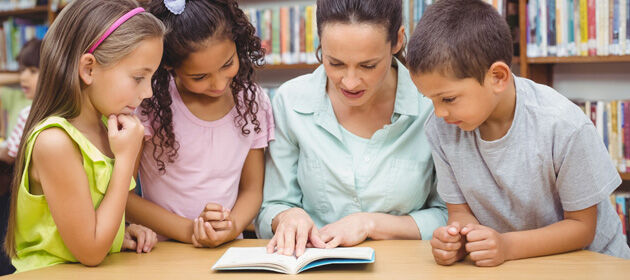 Frau liest drei Kindern vor