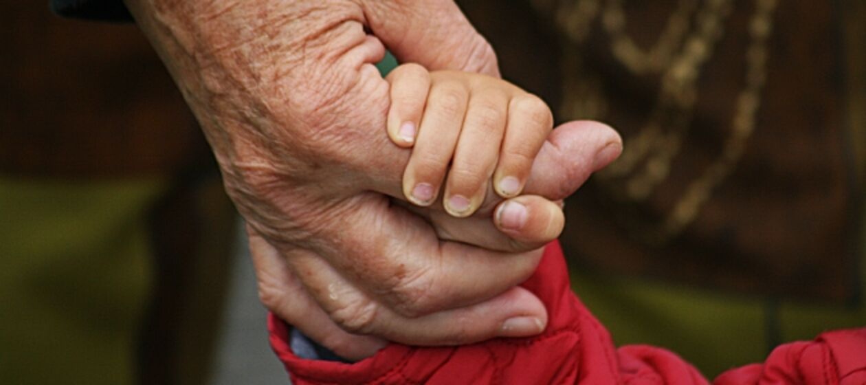Eine Hand greift nach einer Kinderhand