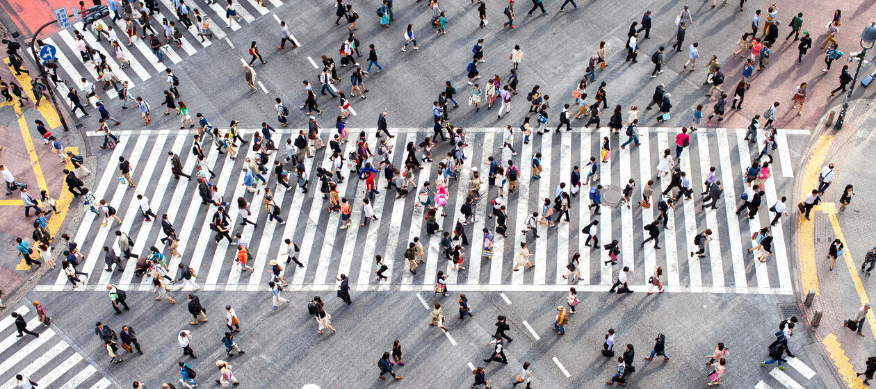 Menschen laufen über einen Zebrastreifen in Tokio