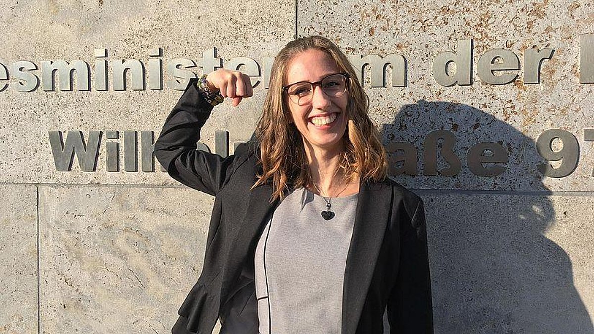 Die 21-jährige Studentin Celina Kühl steht lachend vor dem Bundesfinanzministerium und ballt die Faus. 