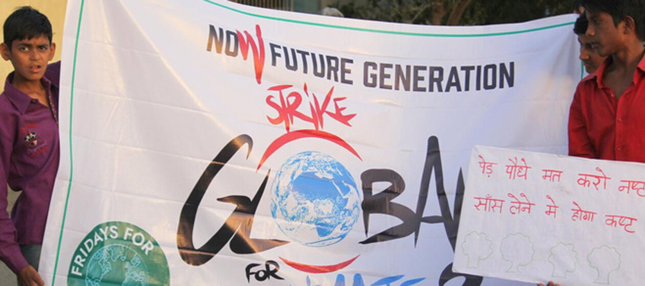 Mehrere Jungs halten ein großes weißes Transparent mit der Aufschrift "Now Future Generation - Global Strike für Climate" 