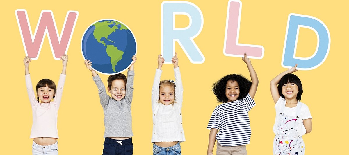 Fünf Kinder halten Schilder mit Buchstaben und einer Weltkugel nach oben, so dass das Wort World zu lesen ist