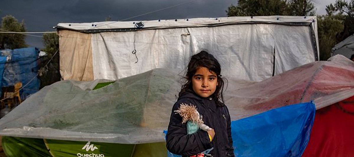Ein Mädchen steht vor einem Zelt im Flüchtlingslager Moria auf Lesbos 