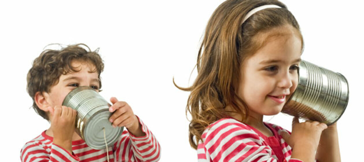 Zwei Kinder experimentieren mit einem selbstgebastelten Telefon