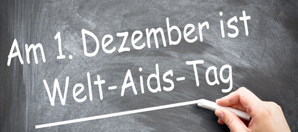 Jemand schreibt auf eine Tafel "Am 1. Dezember ist Welt-Aids-Tag"