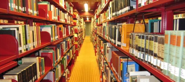 ein Gang einer Bibliothek mit langen Bücherregalen