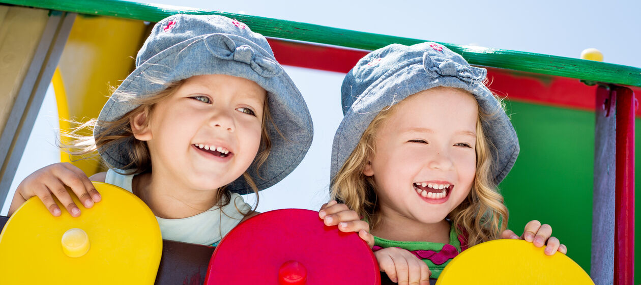 Mädchen mit Hüten auf dem Spielplatz
