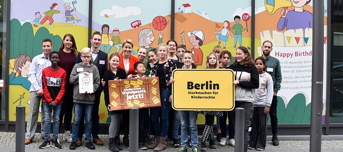 Eine Gruppe Kinder und Jugendliche steht mit der Bundesfamilienministerin Giffey zusammen, im Vordergrund ist ein Plakat zu sehen mit der Aufschrift "Berlin, stark machen für Kinderrechte"
