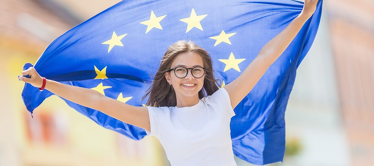 Eine Jugendliche schwingt eine Europaflagge hinter sich