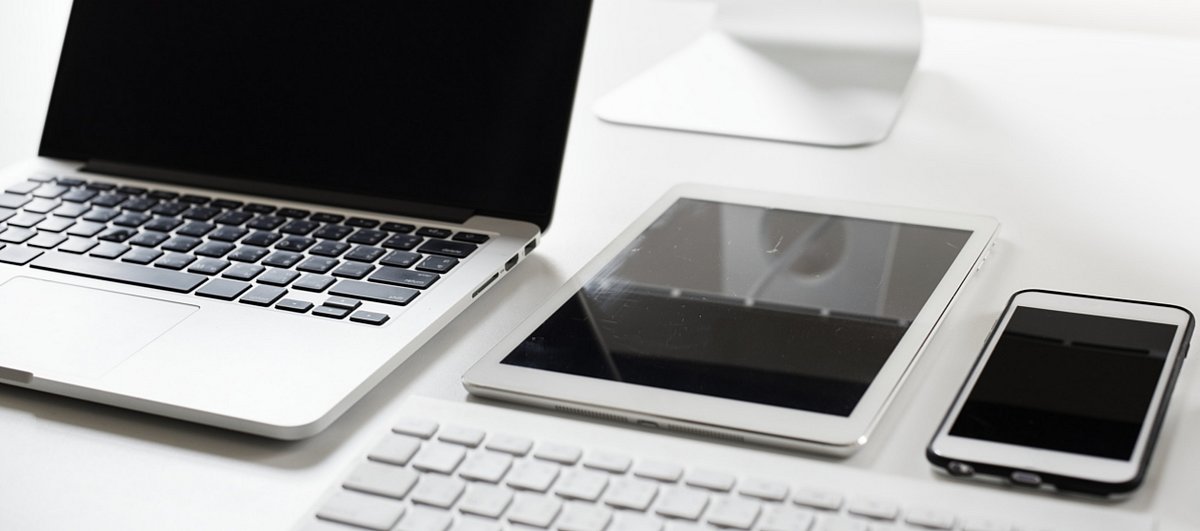 Laptop, Tablet und Smartphone liegen auf einem Schreibtisch 
