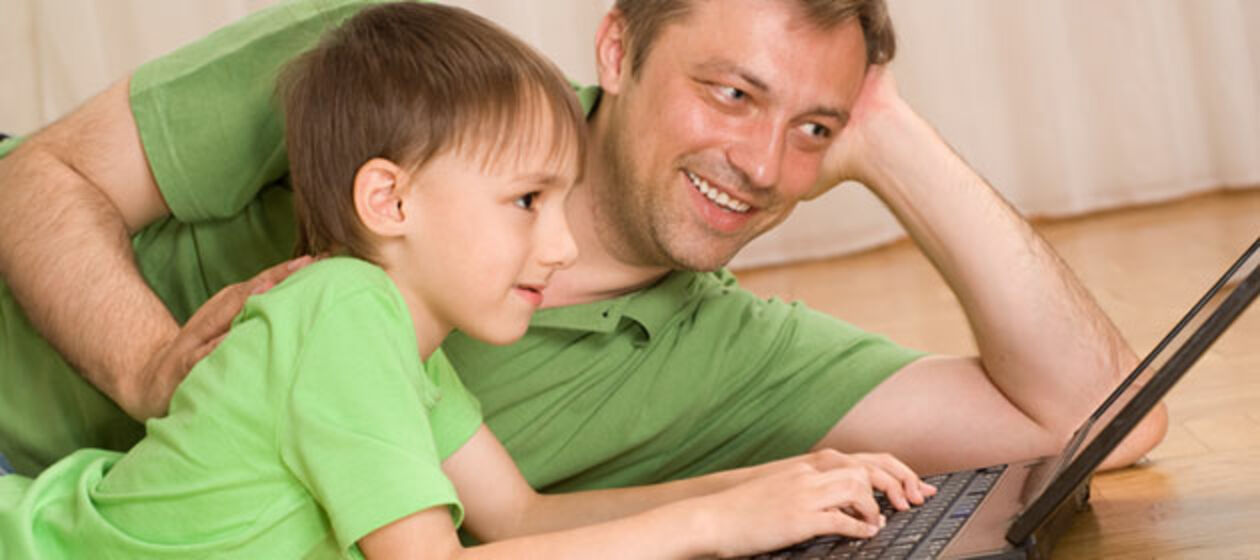 Vater und Sohn beschäftigen sich mit dem Laptop