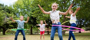 Meherere Kinder spielen mit Hula Hoops
