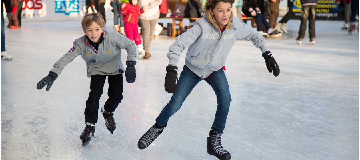 Zwei Jungen laufen auf dem Eis