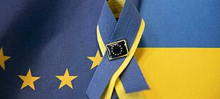 Die ukrainische und europäische Flagge mit einer Solidaritätsschleife vebunden.