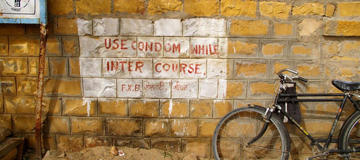 Ein Fahrrad vor dem Slogan "Use condom while intercourse"