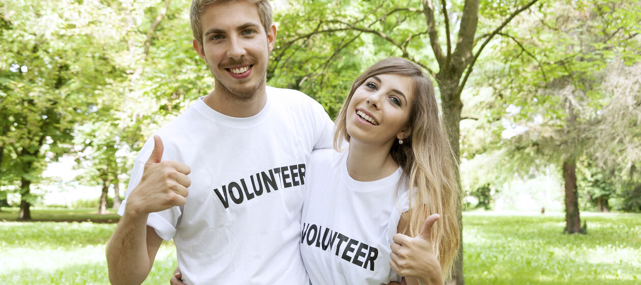 Zwei Jugendliche mit T-Shirts auf denen Volunteer steht