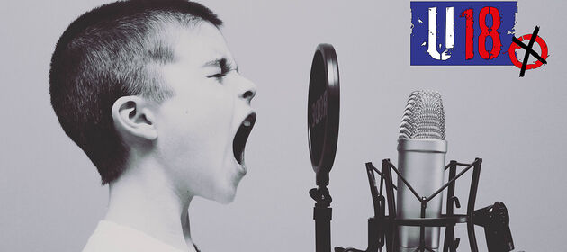 Ein Junge ruft in ein Radiomikrofon. Oben rechts im Bild ist das Logo der U18-Wahl zu sehen.