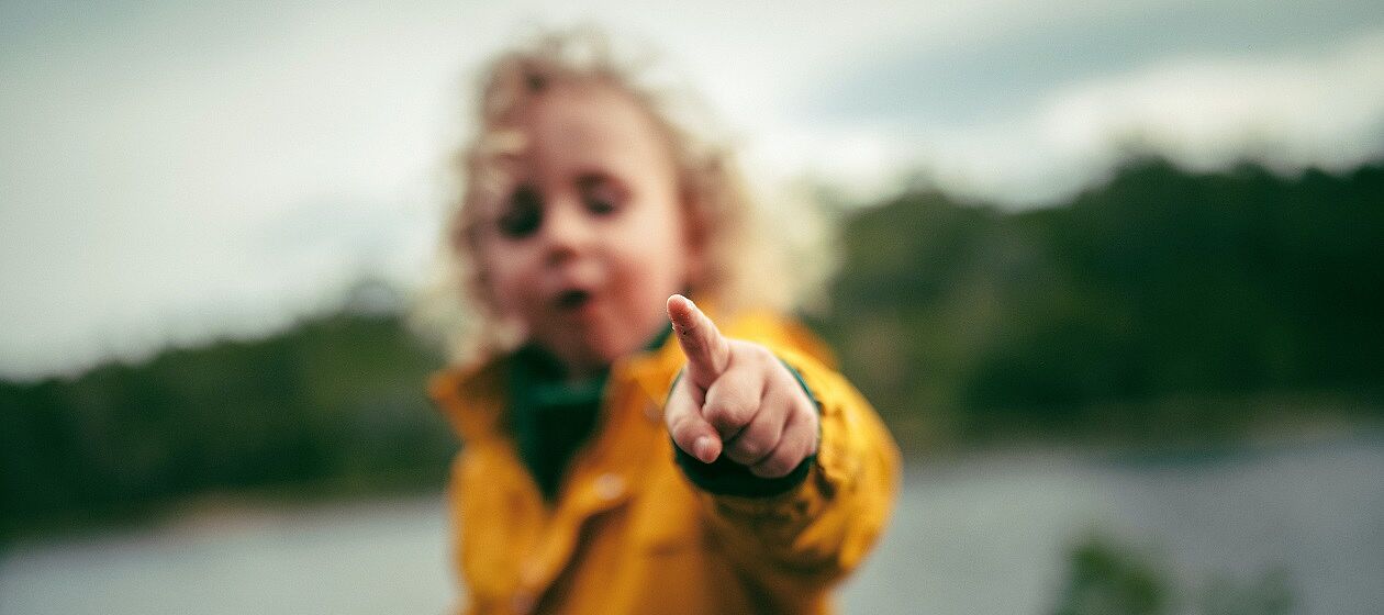 Ein Kind zeigt mit dem Finger in die Kamera