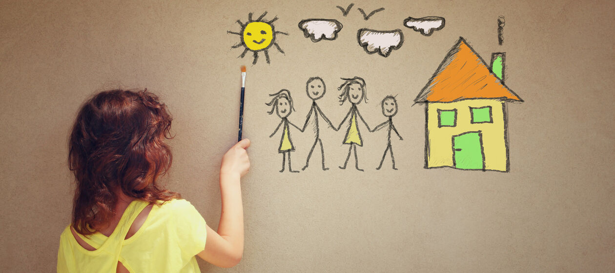 Kind malt Familie mit Haus an die Wand