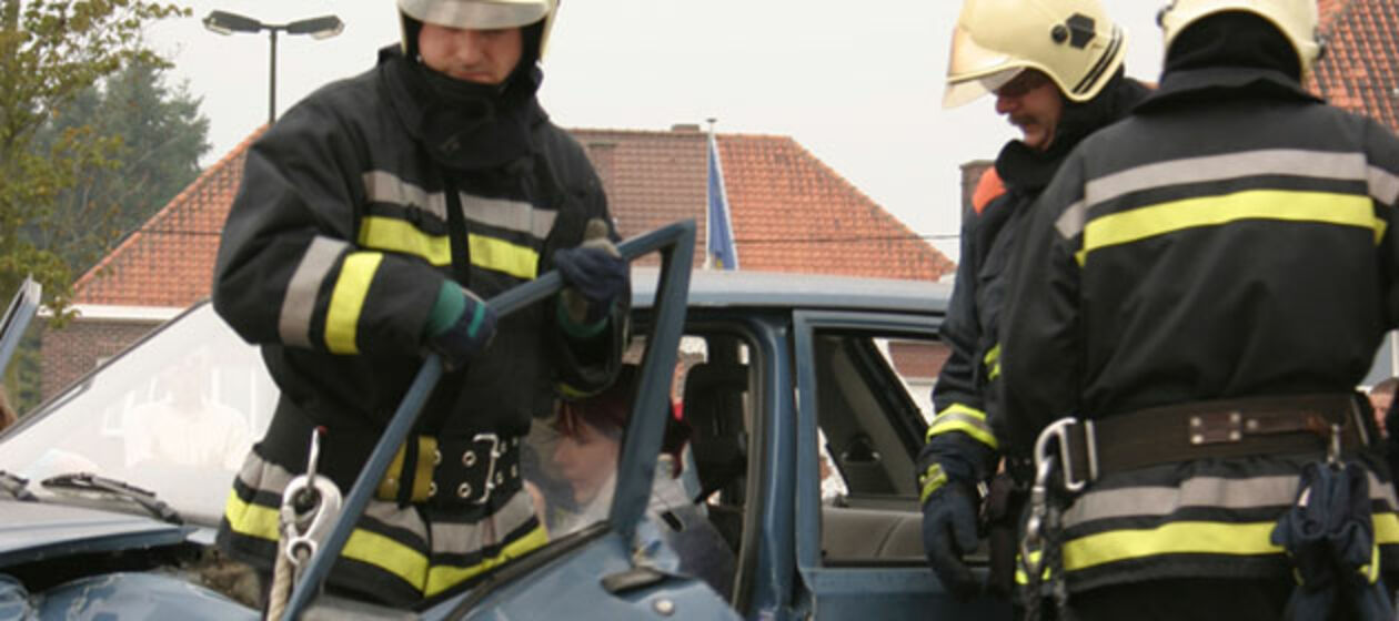 Ein verunfalltes Auto mit Feuerwehrmännern