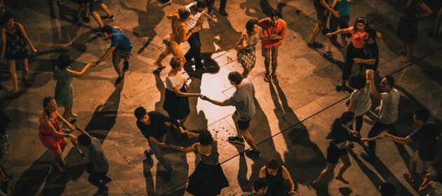 von oben fotografierte tanzende Paare auf einem Platz an einem sommerlichen Abend