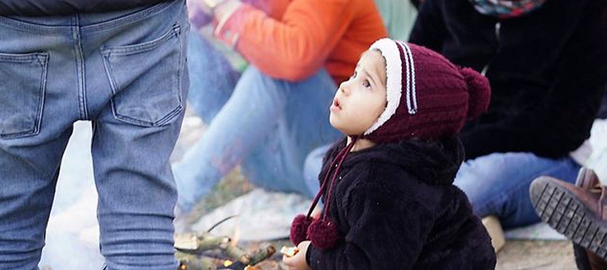 Ein Kleinkind wärmt sich an einem Feuer in der Nähe der griechischen Grenze 