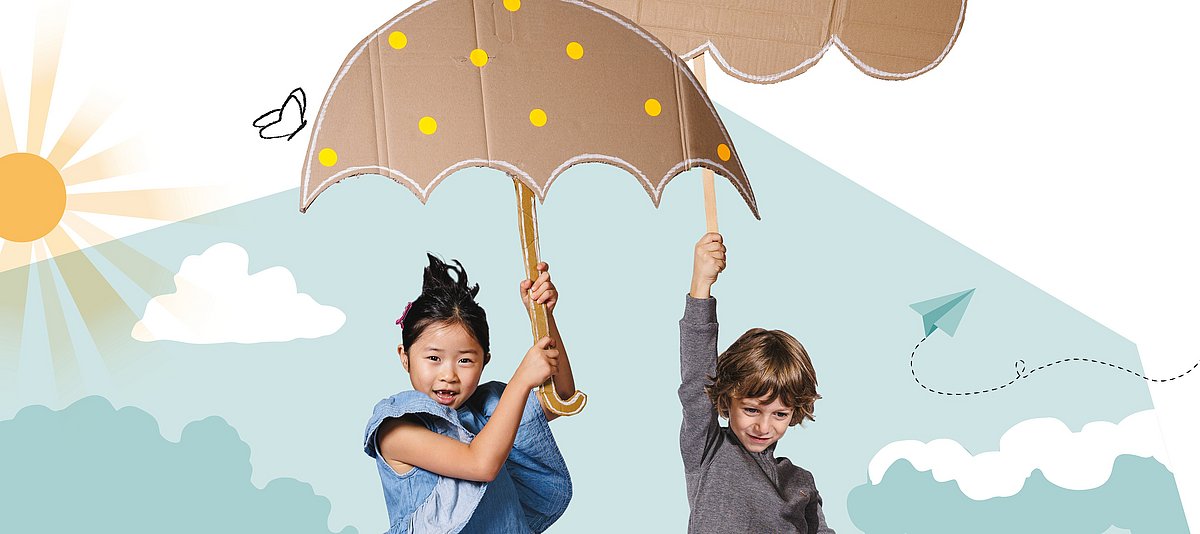 Auf dem Bild sind zwei Kinder zu sehen, die einen Regenschirm aus Pappe tragen 