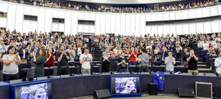 Jugendliche applaudieren an den Abgeordnetenplätzen stehend im Plenarsaal des Europäischen Parlaments in Straßburg.