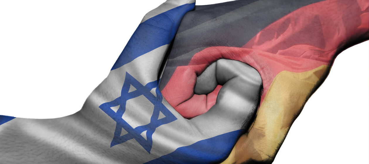 Ineinandergreifende Hände mit deutscher und israelischer Flagge