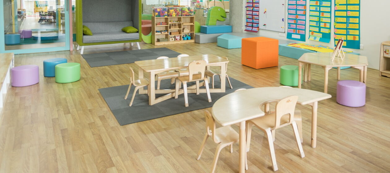 Eine leerer Raum in einer Kita, in dem Tische, Stühel und Spielsachen für Kinder stehen