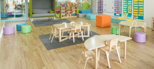 Eine leerer Raum in einer Kita, in dem Tische, Stühel und Spielsachen für Kinder stehen