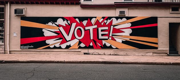 Auf einer Hauswand ist ein Graffiti mit der Aufschrift Vote